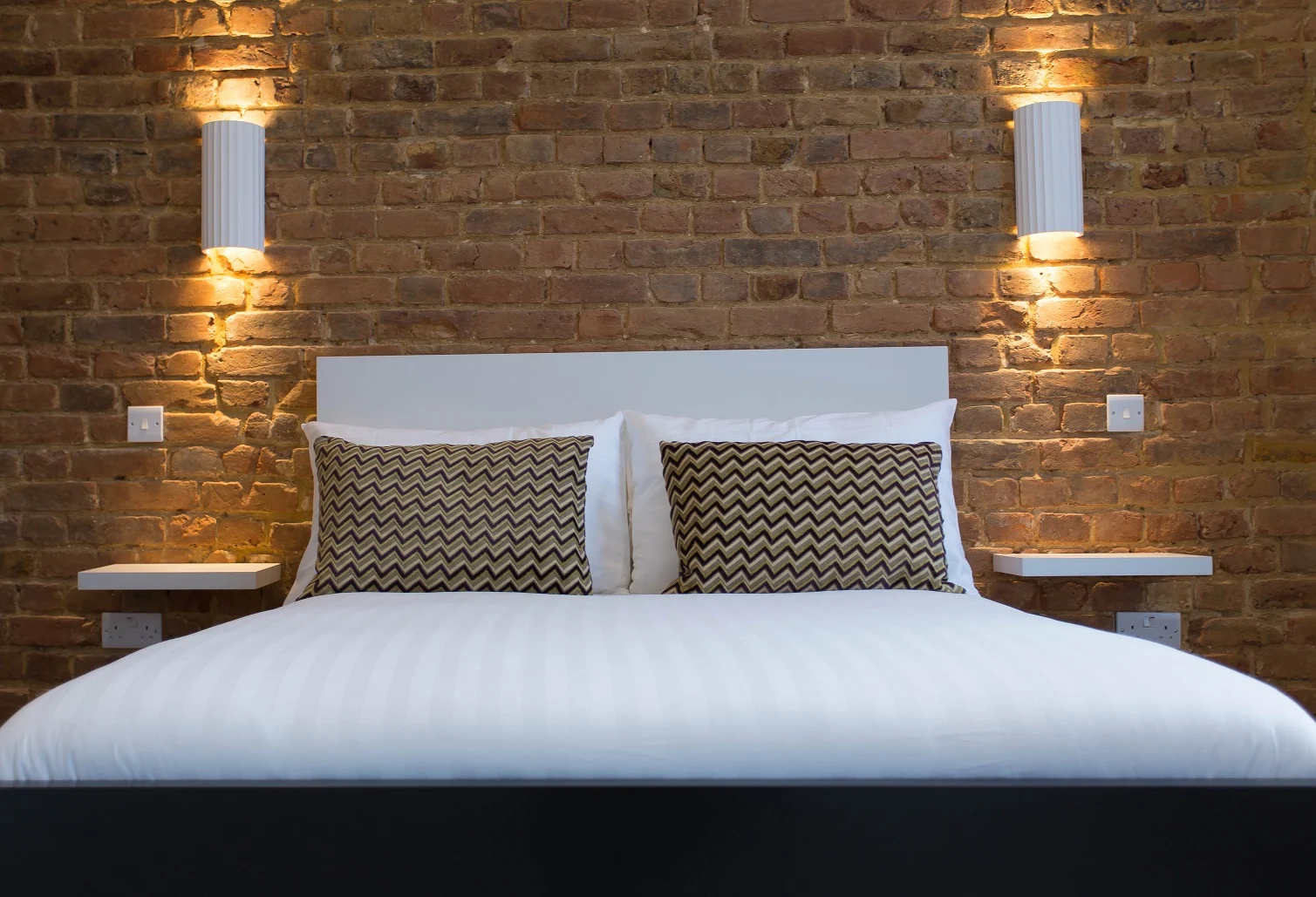 Islington studio with exposed brick and warm bedside lighting